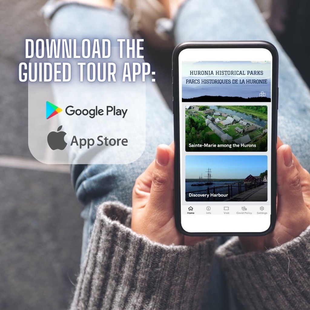 Someone holding a phone which is displaying the Huronia Historical Parks app. Text on the image reads: Download the Guided Tour App. Google Play. App Store.