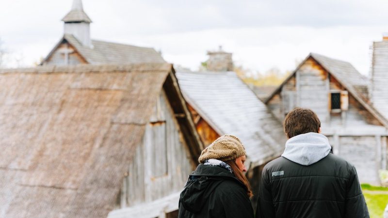 Two people looking at a map and standing on the bastion at Sainte-Marie among the Hurons