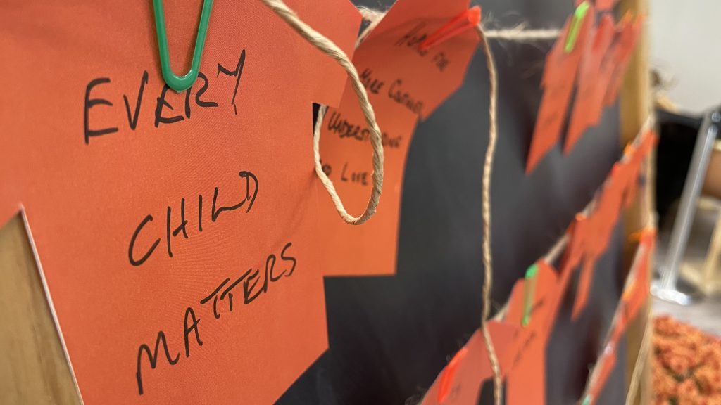 Orange T-shirt cut outs with the words "every child matters"