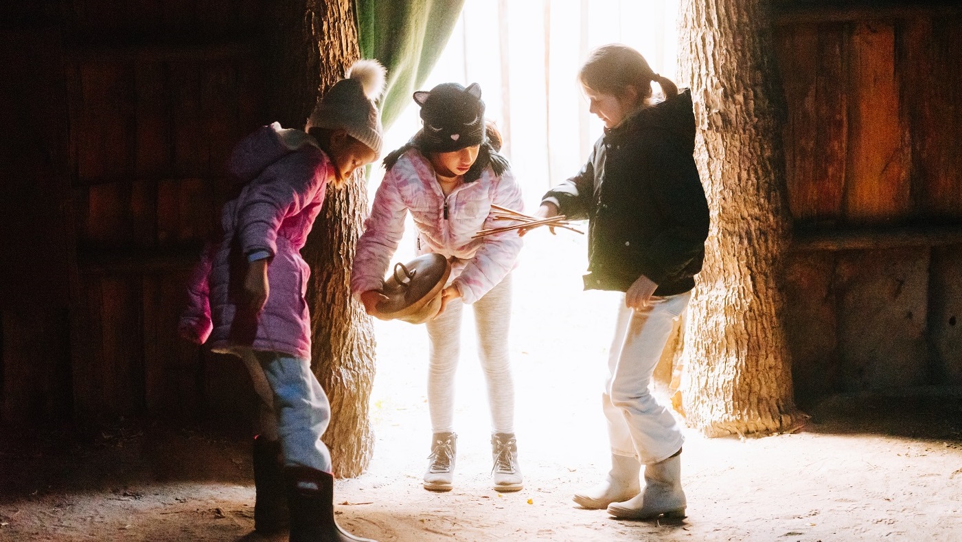 Three young guests of Sainte-Marie among the Hurons play games inside the longhouse