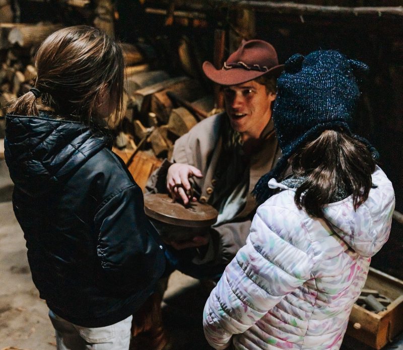 A historical interpreter talking to kids in a longhouse