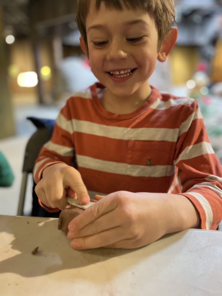 A young guest working with clay inside Sainte-Marie's museum