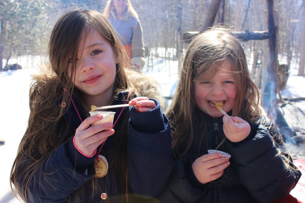 Two guests enjoying maple taffy
