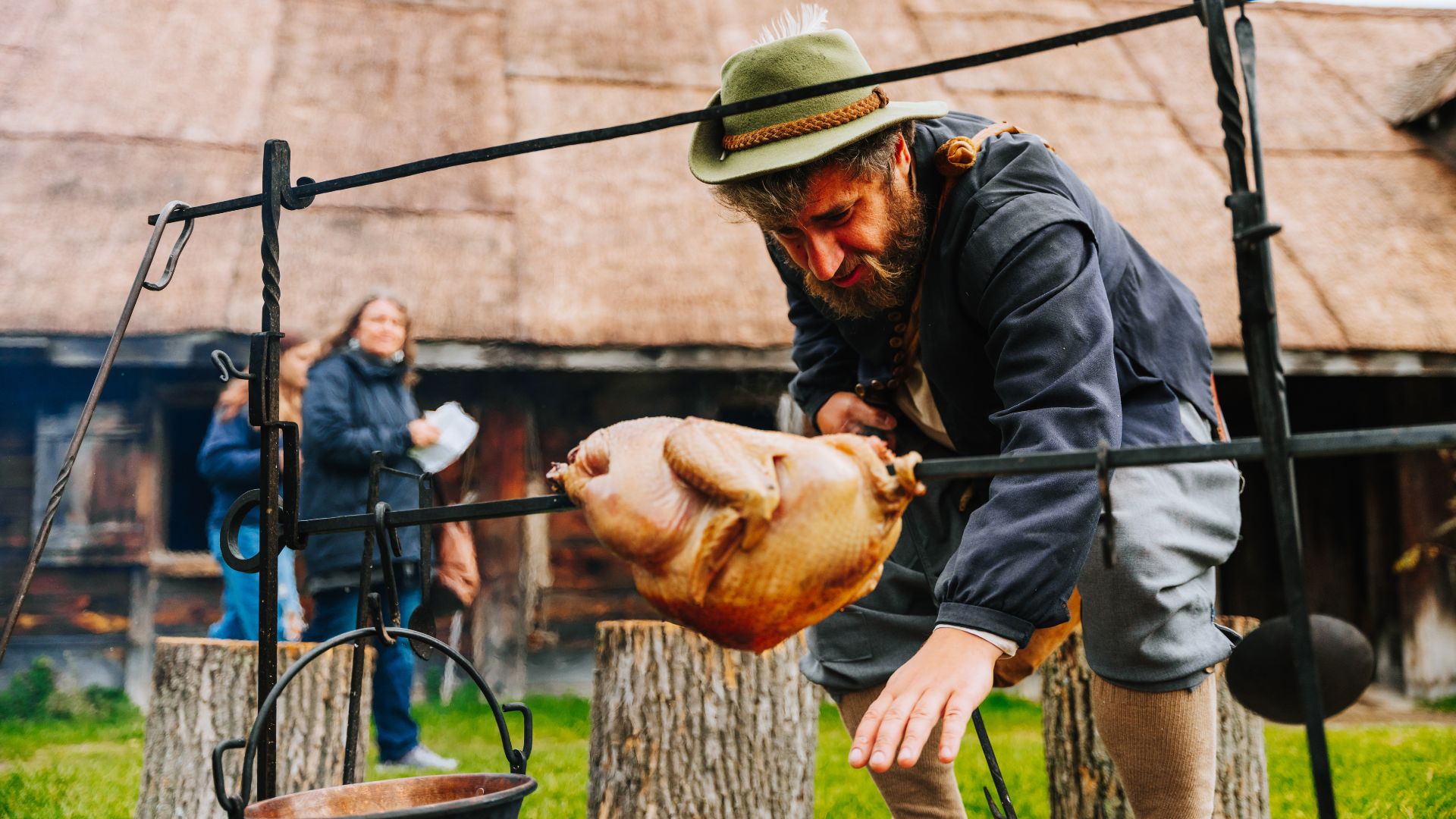 A historical interpreter roasts a duck on a spit