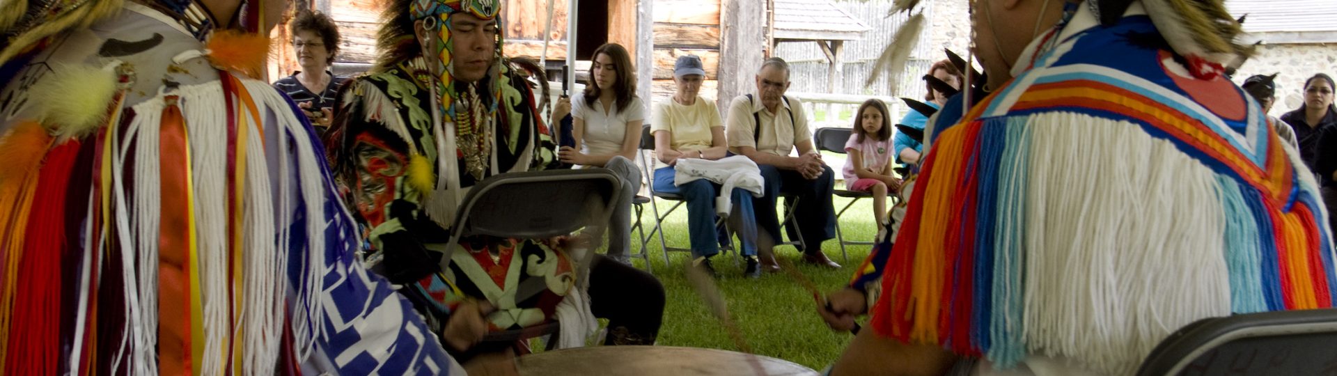 Three young Sainte-Marie visitors play games in the longhouse