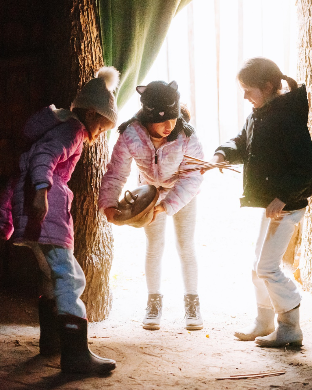 Three girls in the longhouse at Sainte-Marie.