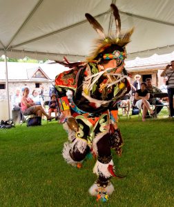 Un danseur autochtone en mouvement, portant un habit cérémonial