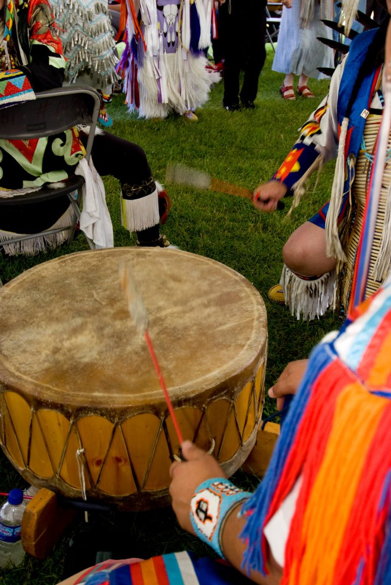 An indigenous person playing a drum