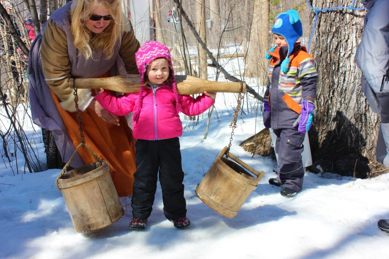 A young visitor holds buckets