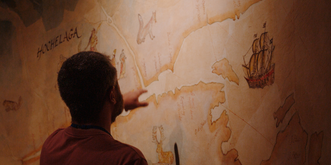 Guest looking at a map mural on the wall inside the museum at Sainte-Marie