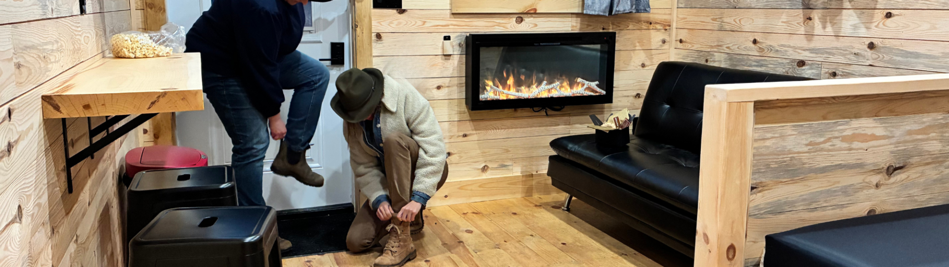 Two guests putting on boots inside at Sainte-Marie cabin