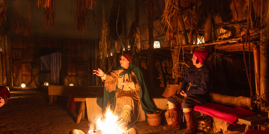 Three girls exploring the inside of the longhouse in the winter